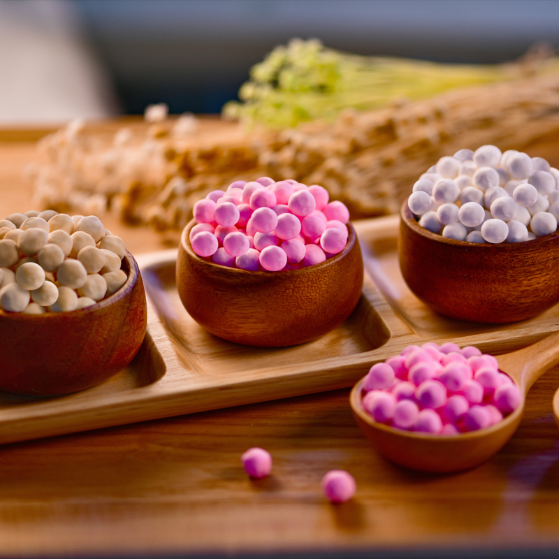 Mini tapioca pearls in various colors displayed in wooden bowls, a key ingredient for Num Wan dessert